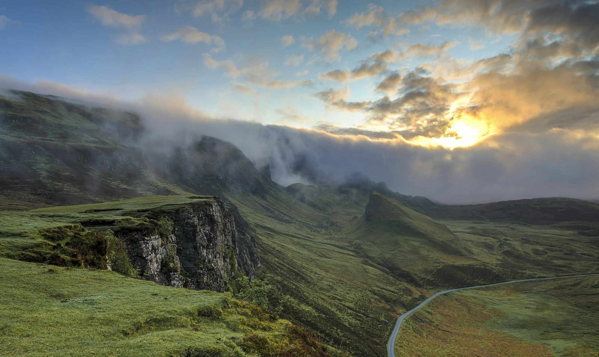 Aerial view of a misty green valley at sunrise (placeholder imagery)
